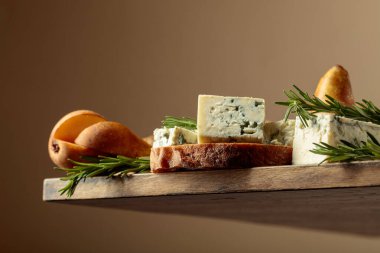 Mavi peynirli, armutlu ve biberiyeli sandviç. Eski ahşap bir ciabatta, mavi peynir, armut ve biberiyenin üzerinde. Aşağıdan görüntüle. 