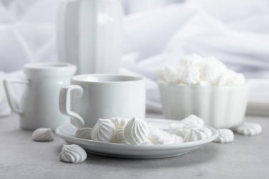 Beyaz vanilyalı krema ve kahve fincanı beyaz mermer bir masada..