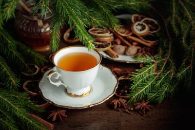 Baharatlı Noel çayı ve eski ahşap bir masada kurutulmuş narenciye dilimleri..