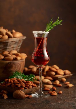Alkolik İtalyan likörü Amaretto. Şarap masasında badem fıstığı var. Boşluğu kopyala.