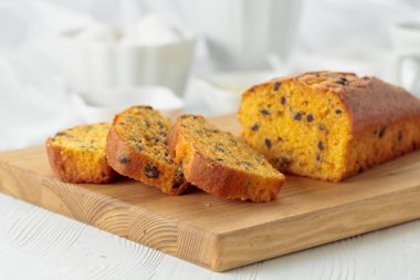 Tahta kesme tahtasının üzerinde çikolata parçaları olan kek..