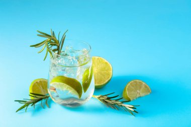 Buzlu, limonlu ve biberiyeli yaz ferahlatıcı içecek. Kopyalama alanı olan mavi arkaplan.