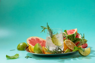 Buz, narenciye, biberiye ve naneli ferahlatıcı bir yaz içeceği. Kopyalama alanı olan yeşil arkaplan.