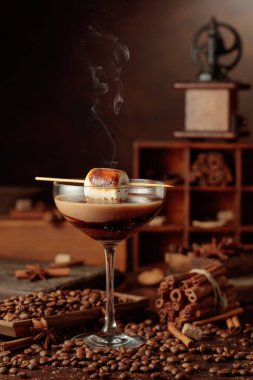 Krema ve kahve kokteyli, kızarmış marşmelovla süslenmiş. Karışık malzeme ve baharatlarla dolu bir masada kahve içeceğiz..