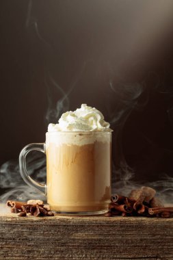 Krem şantili cam bardakta kahve içmek. Eski ahşap bir masada anason, tarçın ve esmer şekerli kahve. Boşluğu kopyala.