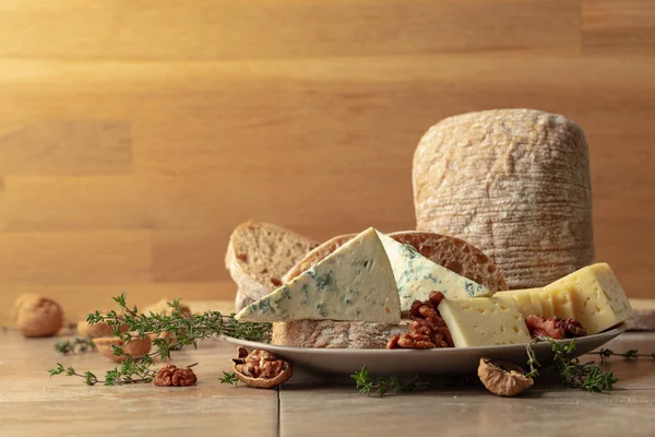 Mutfak masasında peynir, ekmek, ceviz ve kekik. Boşluğu kopyala.