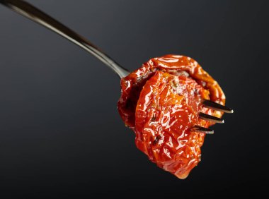 Zeytinyağında kurutulmuş domates. Siyah arka planda geleneksel İtalyan atıştırmalığı. Boşluğu kopyala.