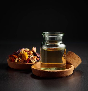 Temel yağ ya da cam şişedeki bitkisel tentür. Siyah arka planda kurutulmuş sağlıklı şifalı bitkiler ve şifalı bitkilerin karışımı. Boşluğu kopyala.