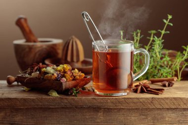 Çeşitli kurutulmuş malzemelerle birlikte bitki çayı ve eski ahşap bir masada taze kekik..