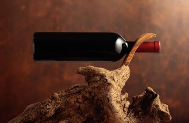 Henüz açılmamış bir şişe kırmızı şarap ve eskimiş eskimiş bir sarmaşık. Kopyalama alanı ile ön görünüm.