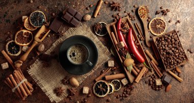 Kahve bazlı aromatik içecekler yapmak için çeşitli baharatlar ve baharatlar. Siyah fincanda sade kahve. Üst görünüm.