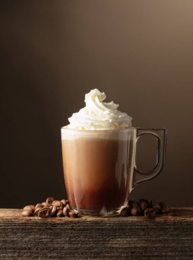 Kahverengi arka planda kremalı kahve ve çikolata. Boşluğu kopyala.