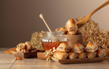 Bej arka planda ceviz ve bal olan baklava. Geleneksel Doğu Çölü ahşap tabakta. Boşluğu kopyala.