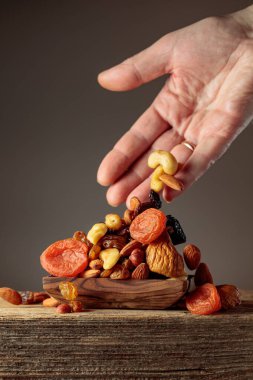 Kurutulmuş meyve ve fındıklar ahşap bir kaba dökülür..