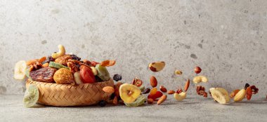 Gri bir arka planda kurumuş meyve ve fındık karışımı. Boşluğu kopyala.