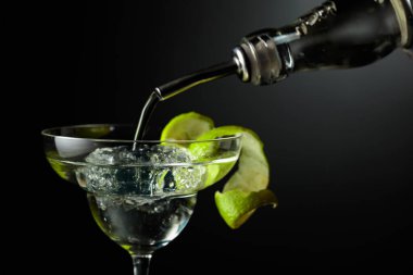 Votka ya da cin buzlu bir bardağa doldurulur. Koyu arkaplanda limon kabuğu olan kokteyl..