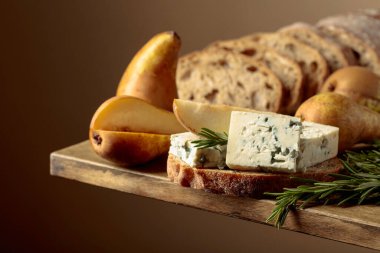 Mavi peynirli, armutlu ve biberiyeli sandviç. Eski ahşap bir masada ciabatta, mavi peynir, armut ve biberiye.