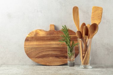 Ahşap mutfak aletleri ve biberiye bir taş masanın üzerinde. Boşluğu kopyala.