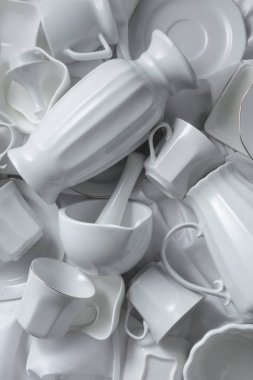 Beyaz kumaş üzerine çeşitli beyaz seramik mutfak malzemeleri. Üst görünüm.