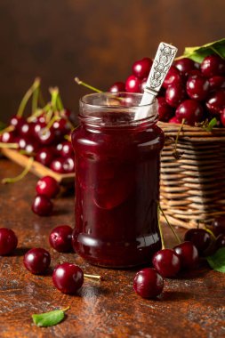 Eski kahverengi bir masada kiraz reçeli ve taze böğürtlen. Boşluğu kopyala.