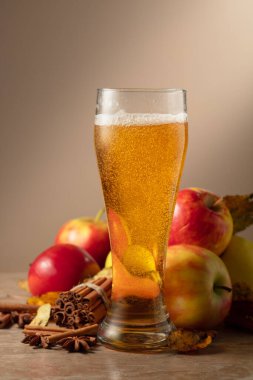 Bardakta elma şarabı. Elmalı, tarçınlı taze karbonatlı içecek ve bej arkaplanda anason..