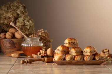 Bej arka planda ceviz ve bal olan baklava. Geleneksel Doğu Çölü ahşap tabakta. Boşluğu kopyala.