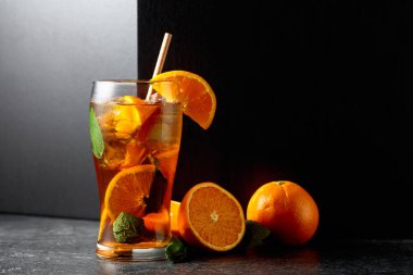 Buzlu, naneli ve portakallı yaz ferahlatıcı içecek siyah taş bir masada. Boşluğu kopyala.