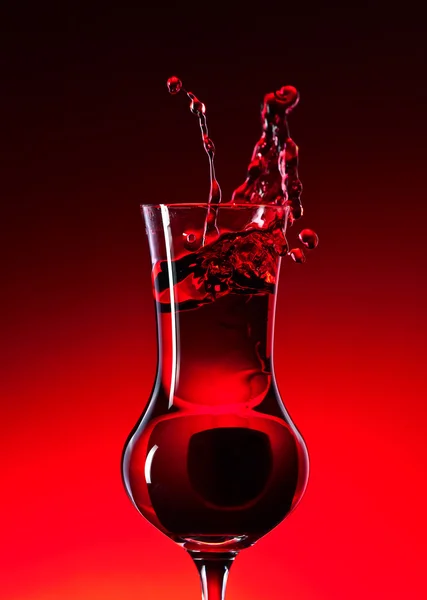 赤の背景にクランベリー酒 — ストック写真