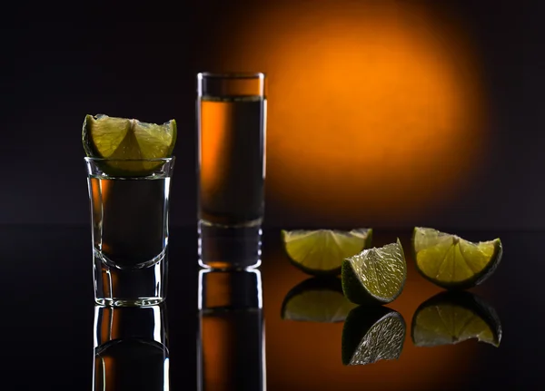 Tequila de ouro em um fundo reflexivo preto — Fotografia de Stock