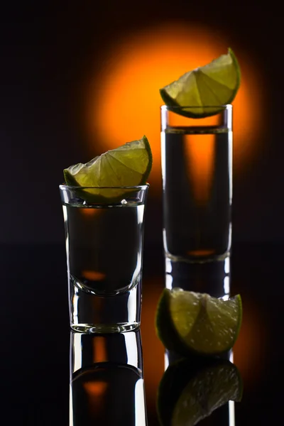 Gold tequila on a black reflective background — Stock Photo, Image