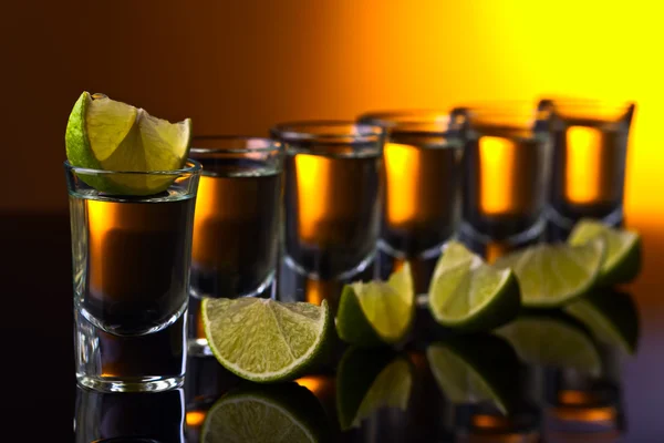 Gold tequila on a black reflective background — Stock Photo, Image