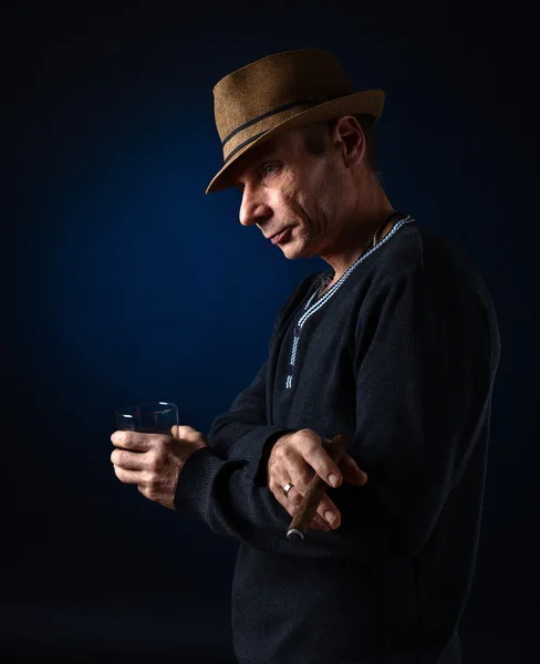 Человек в шляпе, курящий сигару — стоковое фото