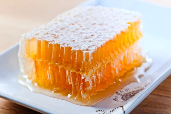 Honungskaka på träbord — Stockfoto