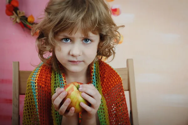 Retrato de uma criança encaracolada com uma maçã — Fotografia de Stock
