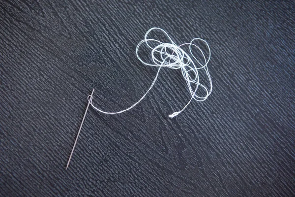 グレーの木の背景に白い糸のスチール針 — ストック写真