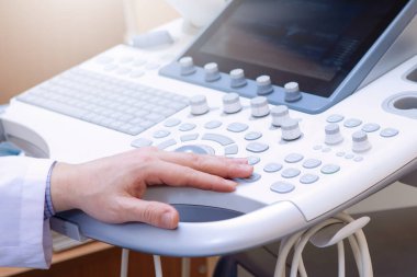 Klinikte ultrason muayenesi. Doktorun eli tarama yapıyor. Doktorun eli klavyede..
