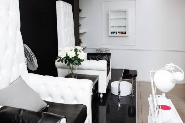 Güzellik Salonu. Siyah ve beyaz gama. Büyük sandalyeleri, ayaklıkları olan pedikür uzmanının işyeri..