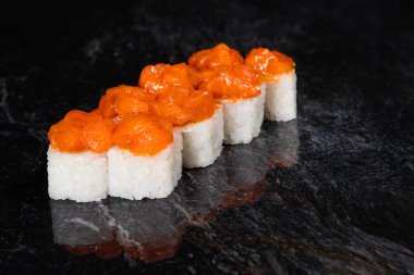 Karides sosundan Japon suşisi, siyah mermer arka planda pirinç..
