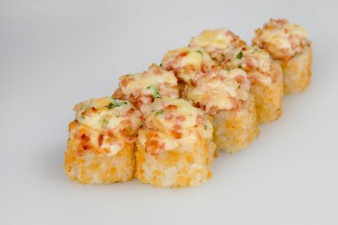 Beyaz bir arka planda jambonlu ve otlu Japon suşisi..