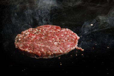 Doğranmış et pirzolası ve elektrikli ocakta dumanla kızartılıyor..