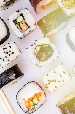 Japon suşi ruloları hazırla, beyaz arka planda susam tohumlu somon balığı. Üst görünüm.