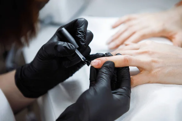 一个戴黑色乳胶手套的美容院美容师的手 — 图库照片