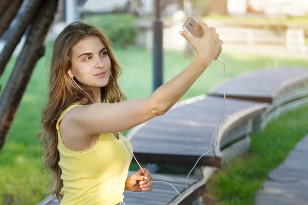 Woman Makes Selfie Smartphone Yellow Shirt Jeans Bench City Park — Stock Photo, Image