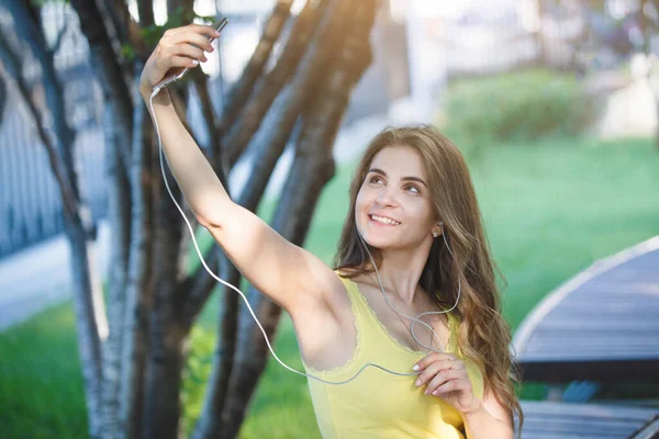 Woman Makes Selfie Smartphone Yellow Shirt Jeans Bench City Park — Stock Photo, Image