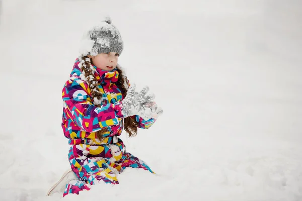 在白雪覆盖的公园里 一个头戴灰色针织帽子的小女孩 — 图库照片