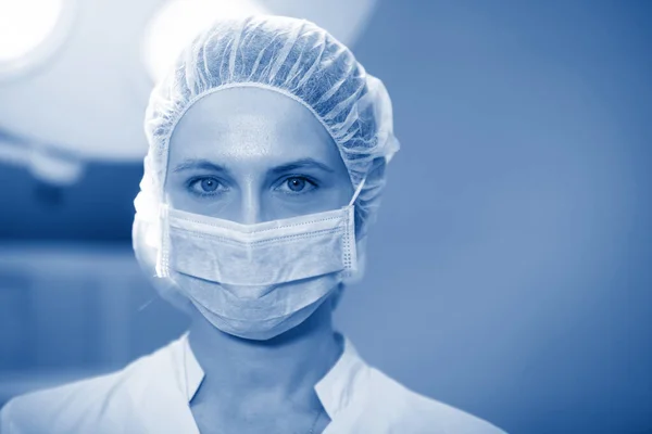 Surgical Nurse in cap and mask in medical clinic. Close-up portrait. Health care, surgery.