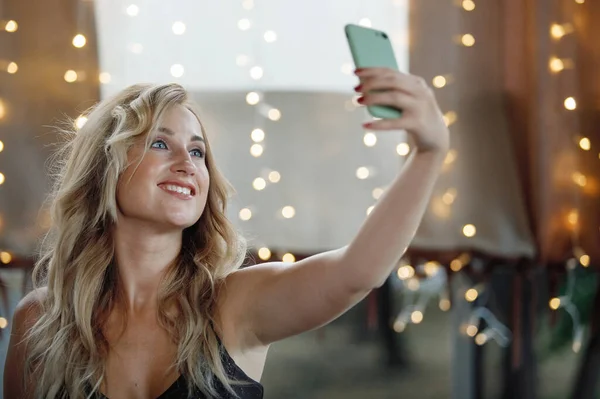 Long Haired Blonde Girl Makes Selfie Smartphone Cafe Background Blurry — Stock Photo, Image