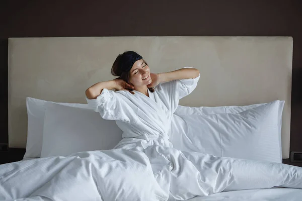 Kobieta Białym Szlafroku Obudziła Się Rano Rozciągała Łóżku Pokoju Hotelowym — Zdjęcie stockowe