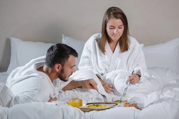 Hombre Barbudo Una Mujer Con Batas Blancas Desayunan Cama Enfoque — Foto de Stock