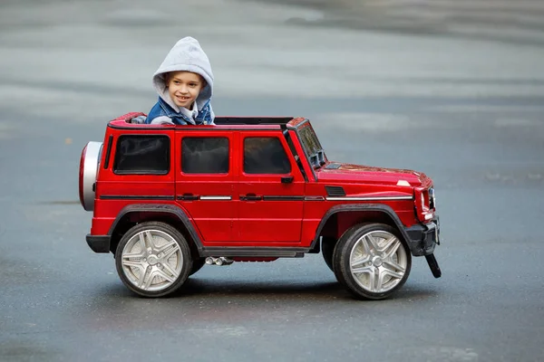 Niño Una Chaqueta Con Capucha Monta Coche Juguete Rojo Para — Foto de Stock